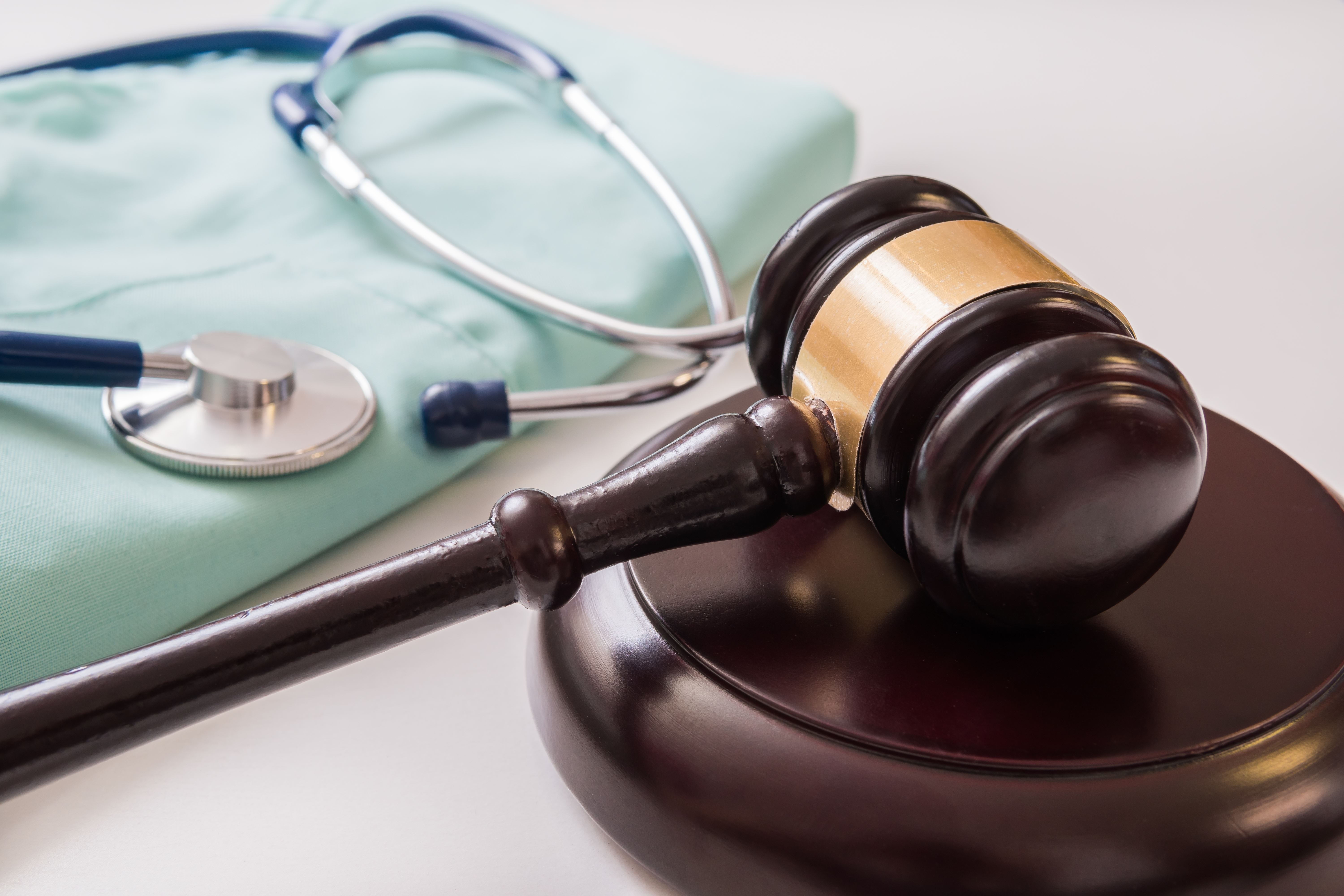 stethoscope resting on scrubs beside gavel